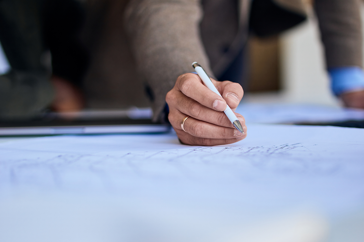 A hand drawing sketches with a pen